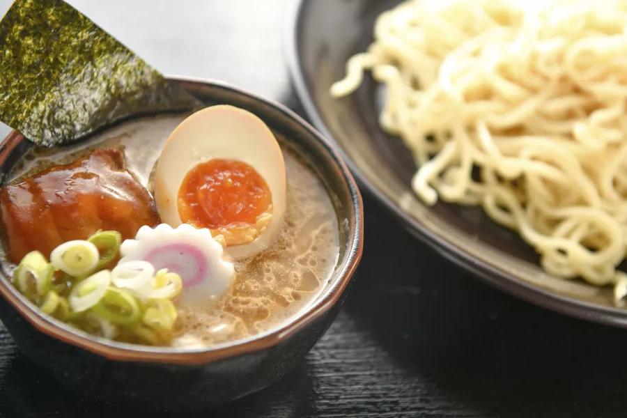 Primer plano de un plato de fideos y un plato de sopa de ramen con un huevo escalfado, 切.