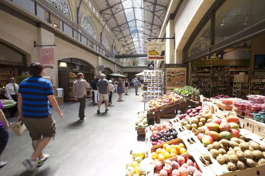 Los compradores caminan por el Ferry Building Marketplace, donde se exhiben productos frescos.